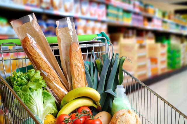 groceries in a grocery cart in an aisle at a grocery store