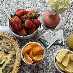 breakfast of fruit and quiche with tea packets