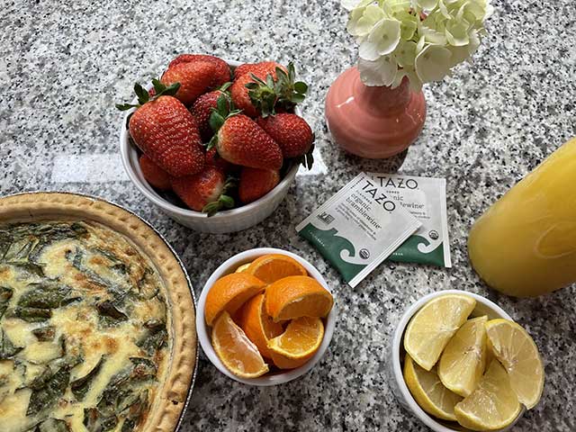 breakfast of fruit and quiche with tea packets
