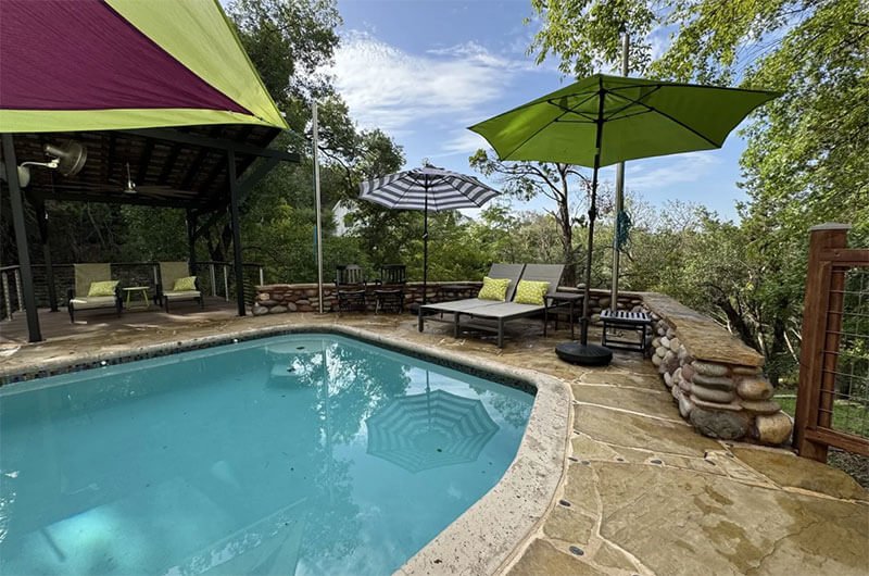 The newly renovated pool at The Rivery Retreat with lounging chairs and pergolas